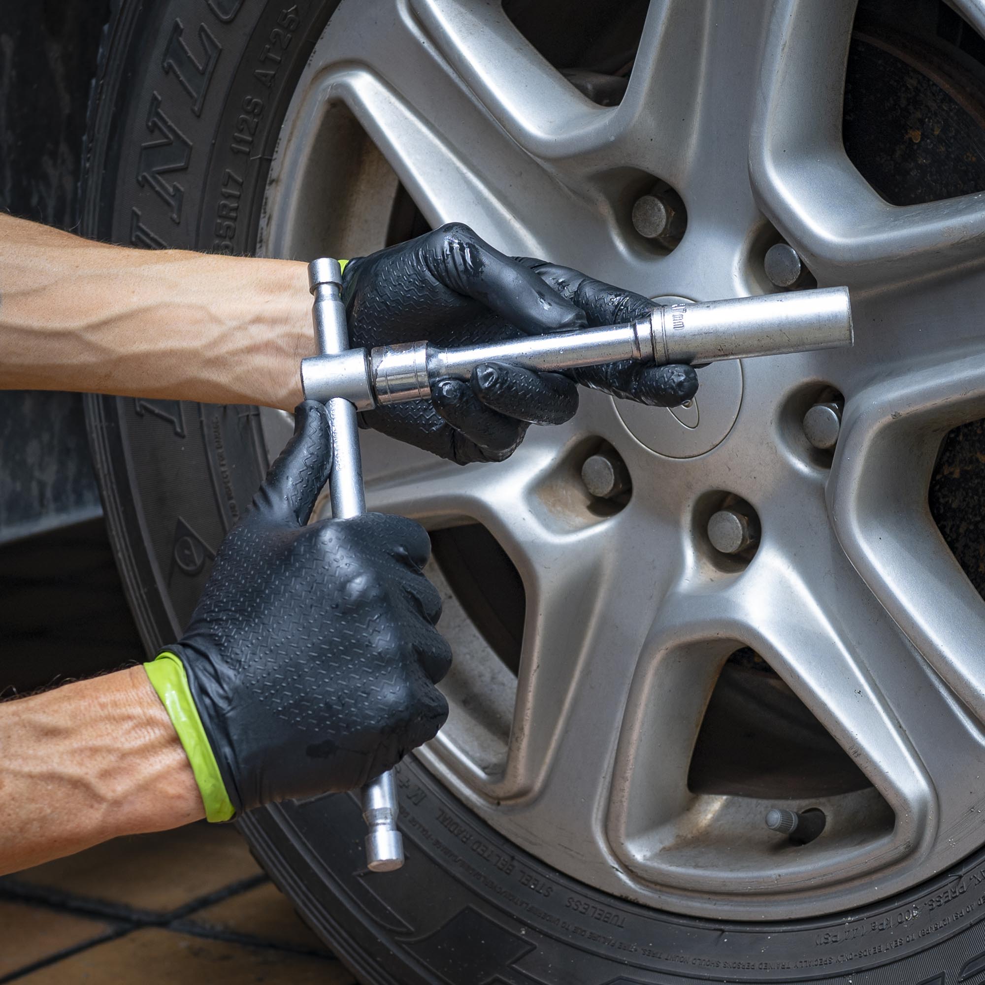 SWIFTEX textured nitrile gloves holding a wheel wrench